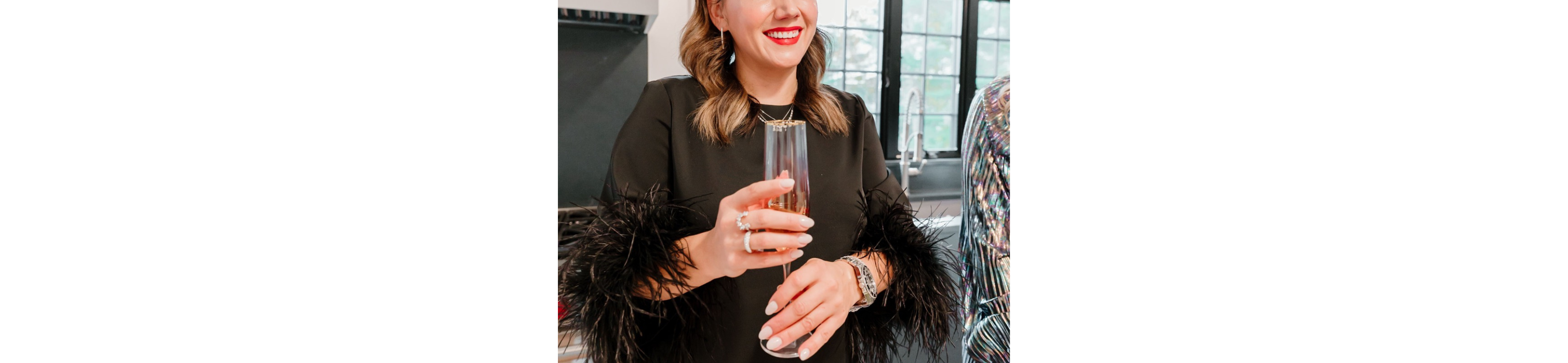 Lilly Mullen styled with rings and a glass of champagne